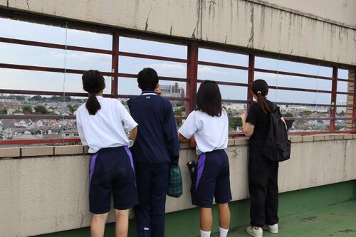 屋上から外を眺める生徒たち