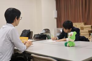 インタビューを行う生徒と受ける職員の画像