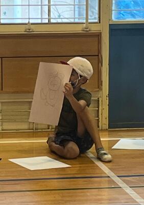 たぬきの絵を見せている児童