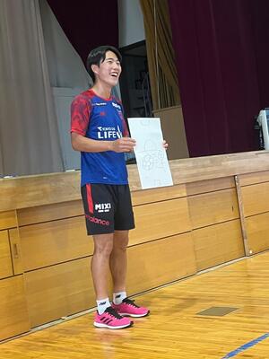 サッカーの絵を見せている佐藤選手