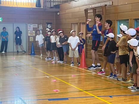 選手が紙飛行機を投げる様子