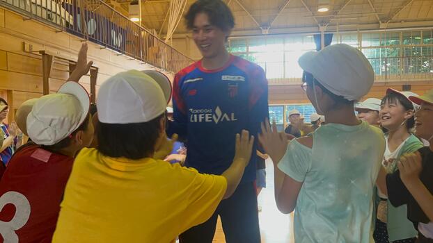 野澤選手が児童たちたちとハイタッチする様子