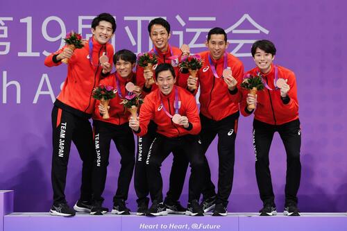銅メダルをと花束を持った日本選手団の集合写真（写真左が春原 選手）