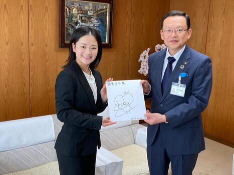 サイン色紙を持つ渡辺選手と市長