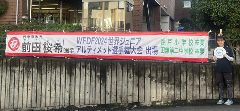 横断幕と写真を撮る前田選手