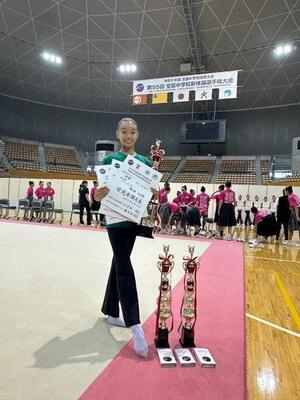 トロフィーと賞状を持っている岡田選手