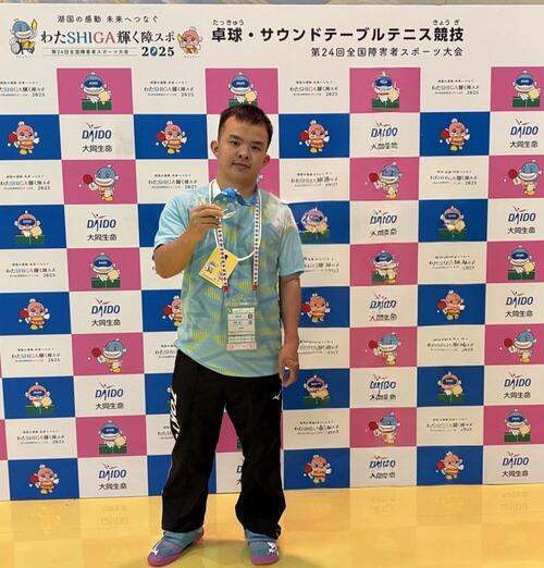 春原選手が金メダルを手に持っている写真