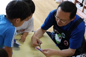 池澤市長折り紙折ってを切る