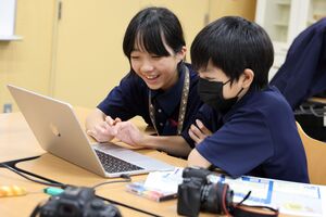 パソコンで写真データを楽しそうに見るカメラマンの二人