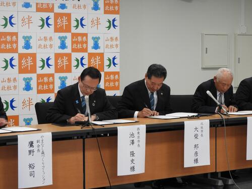 協定書にサインしている写真