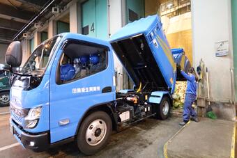ごみ収集車から集積所にごみを排出している様子
