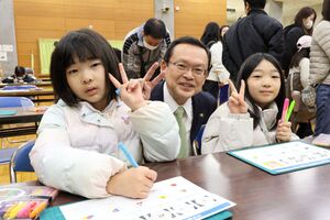 時計を作っている子ども二人と市長との記念写真