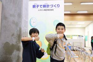 出来上がった腕時計をつけている少年二人